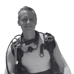 A black and white portrait of Ben, a young white man with short hair and wearing scuba gear